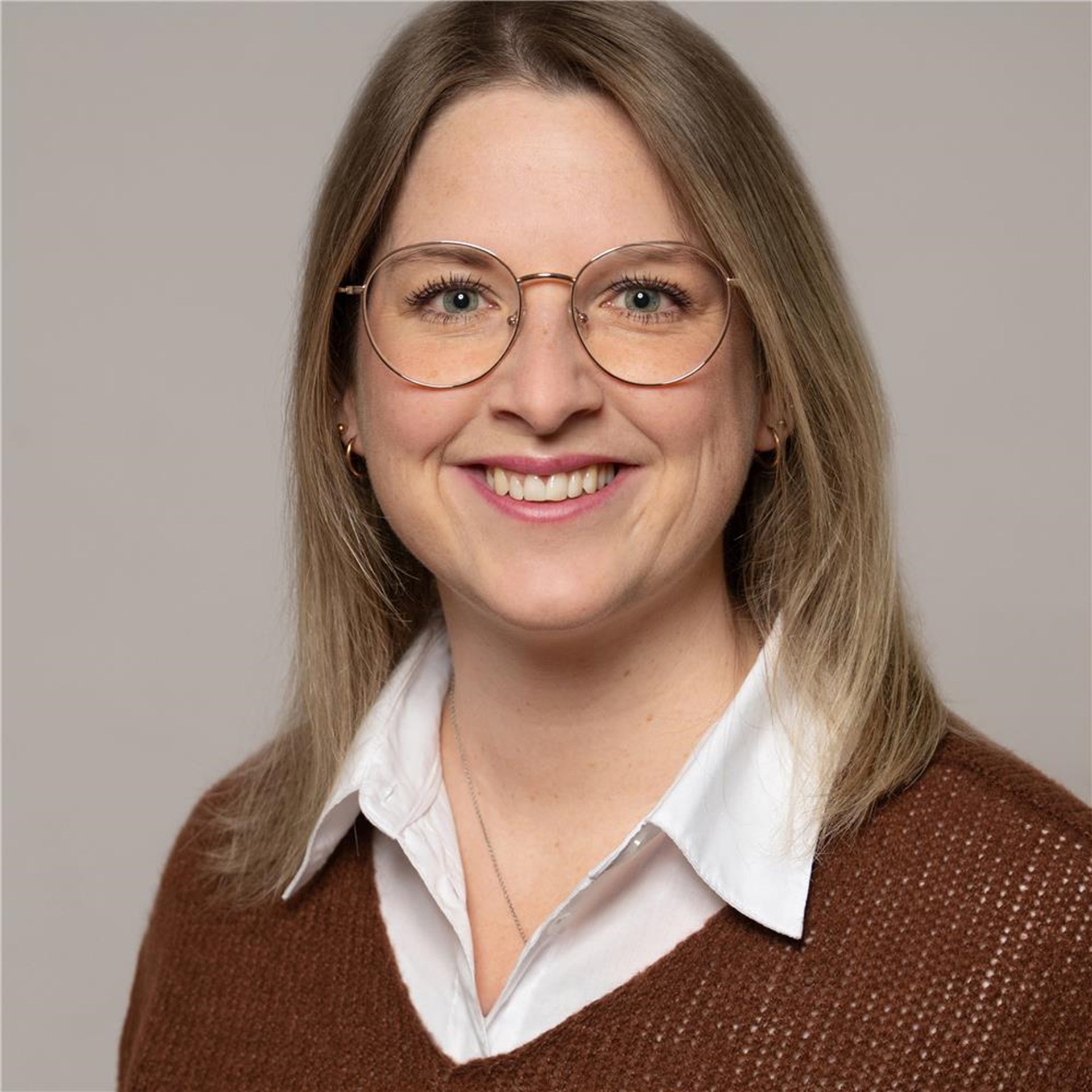 Haas, Larissa
lächelnde mittelblonde Frau mit Brille, braunes Oberteil mit darunterliegender weißen Bluse